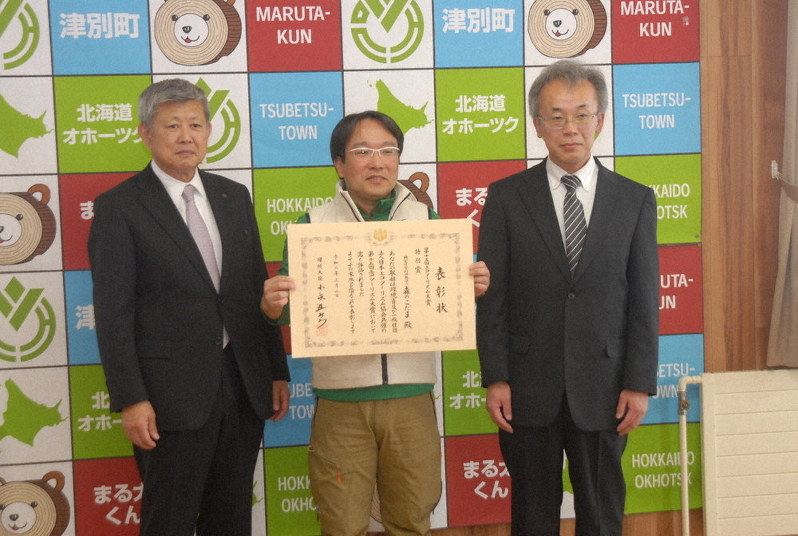 エコツーリズム大賞で特別賞に選ばれた「森のこだま」の代表、上野真司さん(中央)=北海道津別町で