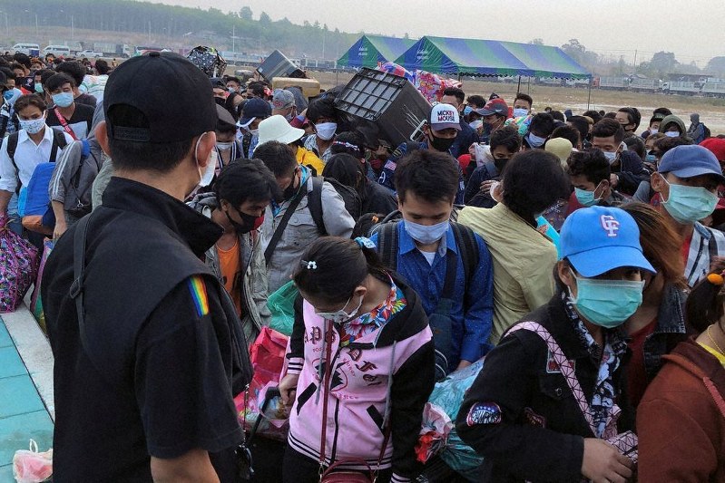 新型コロナウイルスの感染拡大を受け、タイから帰国しようと国境沿いに集まるミャンマーからの出稼ぎ労働者ら=タイ北西部メソトで25日、ロイター