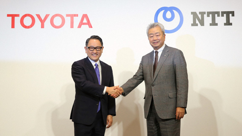 資本提携の発表会見で握手を交わすトヨタ自動車の豊田章男社長(左)とNTTの澤田純社長