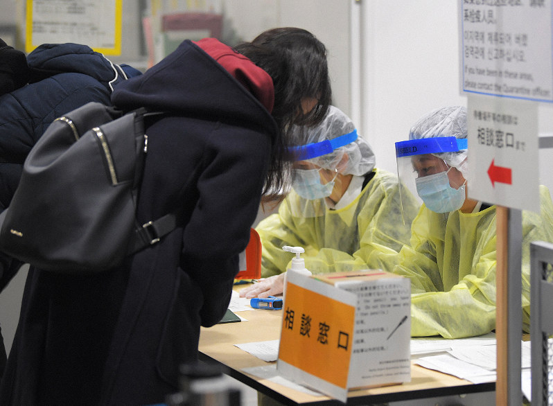 入国制限が強化される中、質問票の記入や2週間の待機要請について検疫で説明を受ける韓国からの便で到着した人たち=成田空港で2020年3月9日午前8時33分、手塚耕一郎撮影