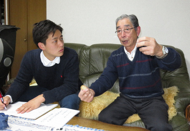 高橋大悟(左)さんに、米軍機が飛来したときのことなどを話す祖父の鍋谷治さん=大阪市旭区で、三角真理撮影