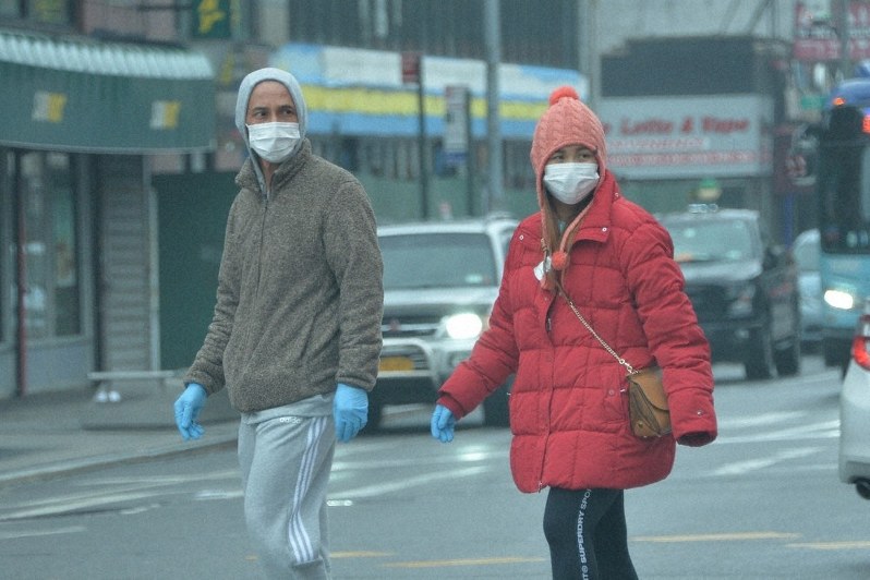 マスクと手袋をして歩く市民=米ニューヨーク市クイーンズ地区で3月29日、隅俊之撮影