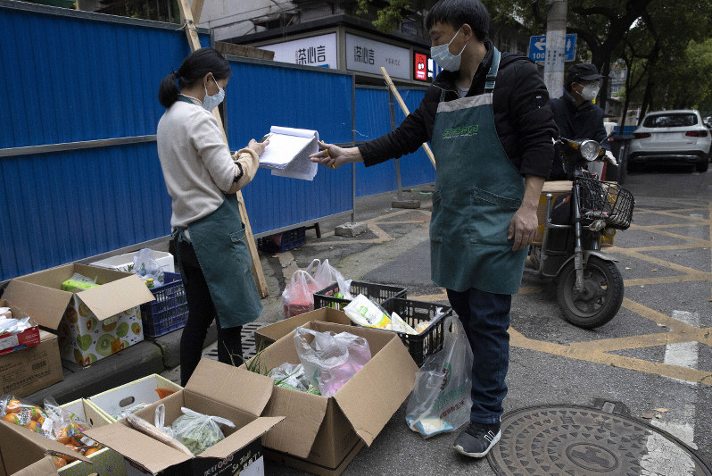 今年4月2日、封鎖された武漢で日用品を配る準備にあたる市民=新華社、AP