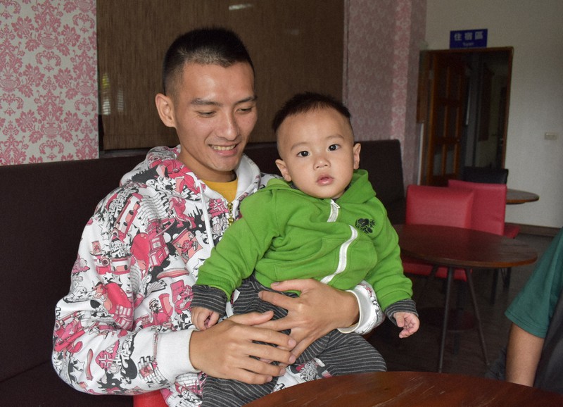 次男の約掌単ちゃんをあやす呉以諾さん=寒渓村で2020年3月14日、福岡静哉撮影
