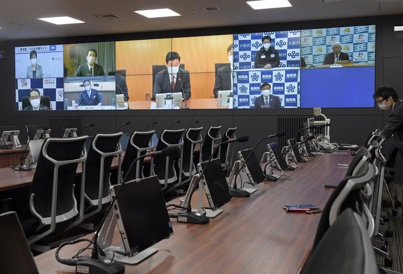 テレビ会議をする西村康稔経済再生担当相(画面中央)と緊急事態宣言の対象となった7都府県の知事=東京都千代田区で2020年4月8日午前11時18分、竹内幹撮影