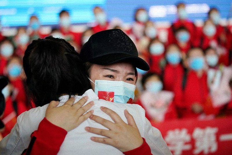 封鎖措置が解除された中国湖北省武漢市の空港で、抱き合う医療従事者ら=8日、ロイター