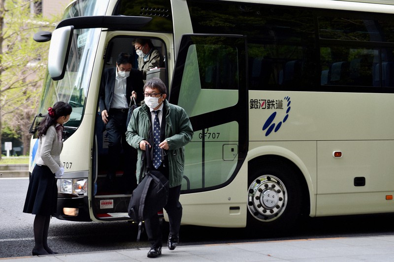 無料運行する銀河鉄道バスを利用し東京駅付近で降りる乗客たち=東京都千代田区で2020年4月10日午前7時42分、滝川大貴撮影