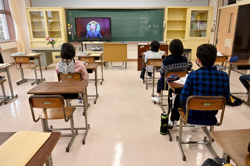 担任発表や教科書配布などのために登校日を設けた千葉市立弥生小で、教室でテレビ越しに校長先生の話を聞く児童たち。席は間隔が広くあけられていた=千葉市稲毛区で2020年4月13日、北山夏帆撮影