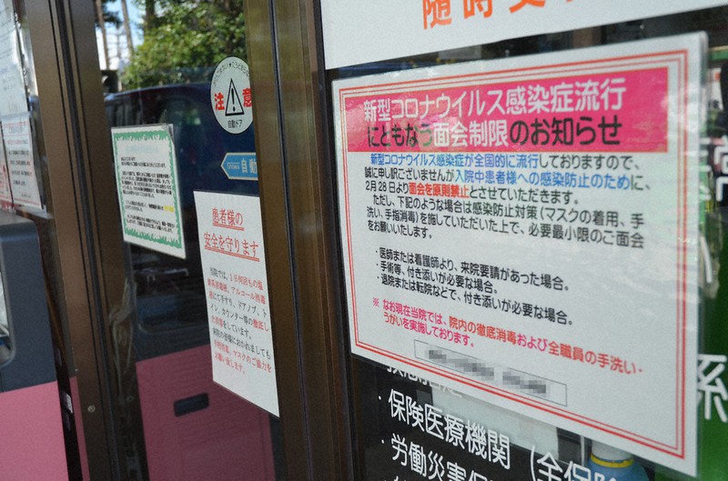 新型コロナウイルスの感染防止のため病院の入り口には面会制限を知らせる紙が張ってあった=東京都杉並区で2020年4月10日、椋田佳代撮影(画像の一部を加工しています)