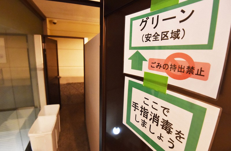 新型コロナウイルスの軽症者らの受け入れに備え、感染者との動線を分ける表示が張られたホテル内の扉=大阪市西区のスーパーホテル大阪天然温泉で2020年4月13日午後5時32分、山崎一輝撮影