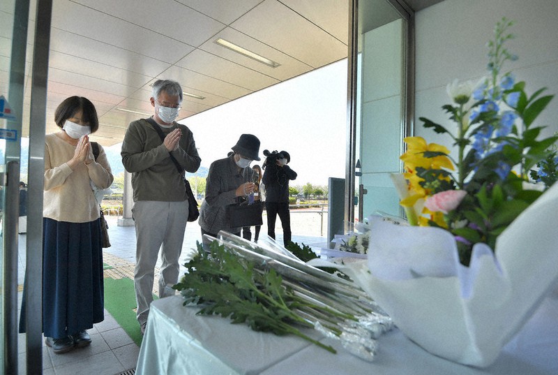 熊本地震の犠牲者を悼み、手を合わせる人たち。新型コロナウイルス対策のため、献花台は町施設の入口に設けられた