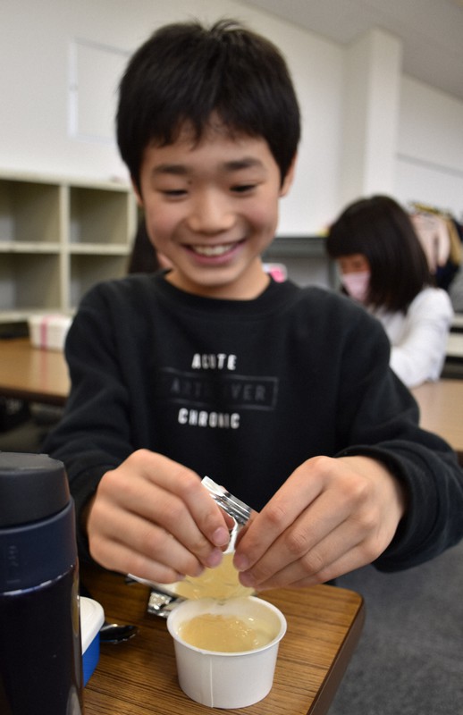 利府町のナシで作ったジャムをヨーグルトにかける小学生＝葉山児童クラブで2020年4月13日午前11時58分、面川美栄撮影