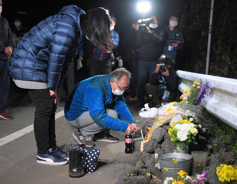 熊本地震の本震発生時刻に合わせ、大和晃さんが発見された阿蘇大橋の崩落現場前を訪れた母大和忍さん(左)大和と父卓也さん(中央)=熊本県南阿蘇村で2020年4月16日午前1時17分、津村豊和撮影
