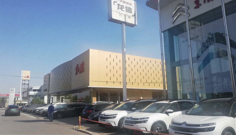 自動車販売店の前に多くの車が止まっているが、ほとんどはナンバープレートを付けていない在庫だ=中国・北京市内で2020年4月13日午後、赤間清広撮影
