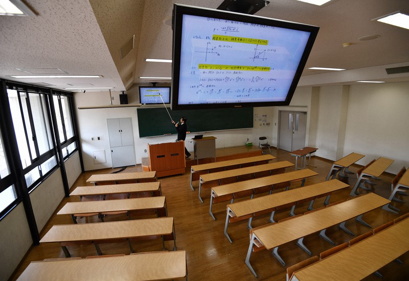 新型コロナウイルスの感染拡大によって大学構内への学生の立ち入りが禁止となり、オンラインで受講できるよう無人の教室で講義を撮影する教員=大阪府豊中市の大阪大豊中キャンパスで2020年4月8日、猪飼健史撮影