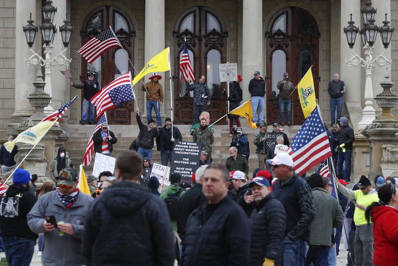 ミシガン州議会議事堂前に集まり、外出制限などに抗議する人々=米中西部ミシガン州ランシングで15日、AP