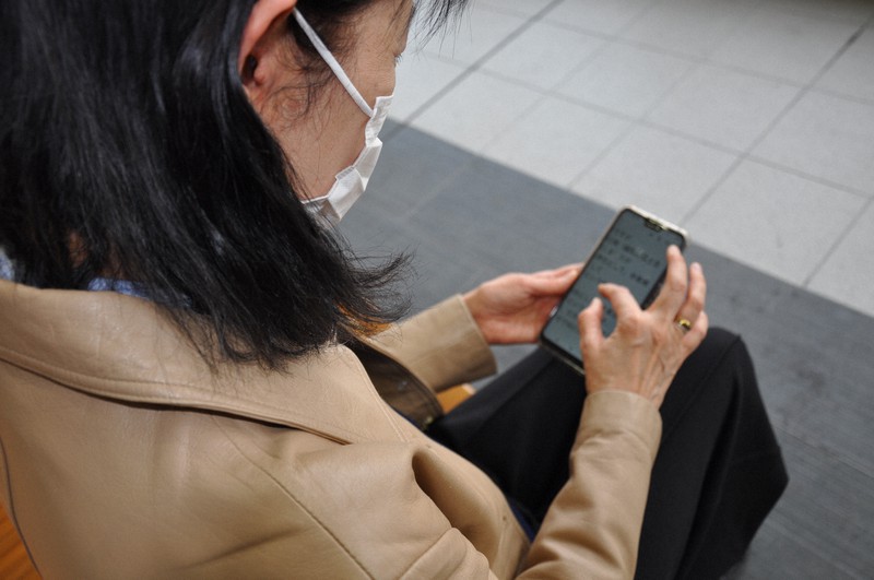 派遣会社から「休業補償しない」と通告されたメールを見つめる女性=大阪府岸和田市で2020年4月15日、桐野耕一撮影