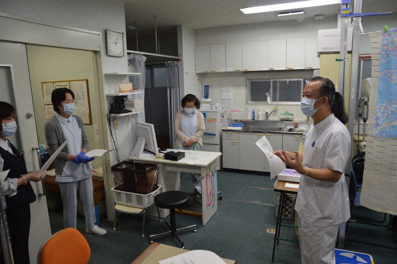 「患者からの相談を親身になって聞きましょう」とスタッフに話す原田文植医師(右端)=東京都台東区で2020年4月21日、吉田卓矢撮影