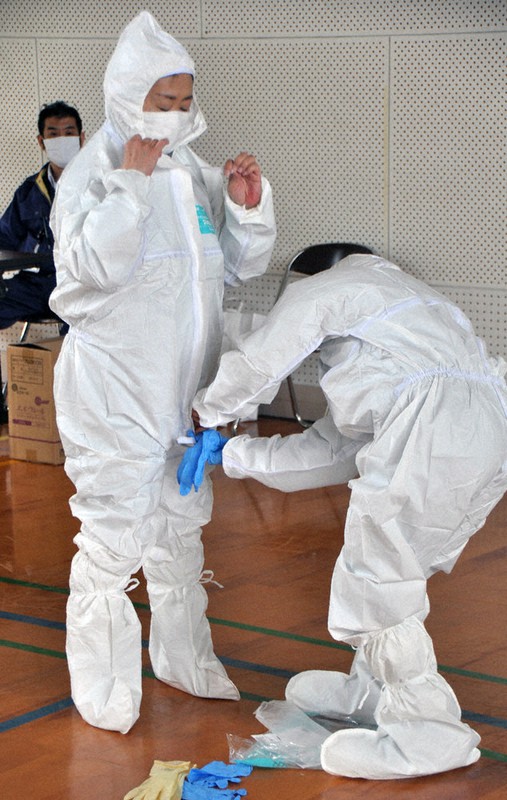 防護服着用を体験する参加者ら=南部町ふるさと交流センターで、柴崎達矢撮影