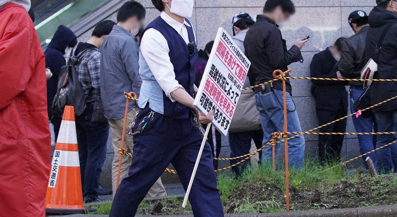 間隔を空けて並ぶよう呼びかける従業員=東京都千代田区で2020年4月23日午前9時29分、玉城達郎撮影(画像の一部を加工しています)