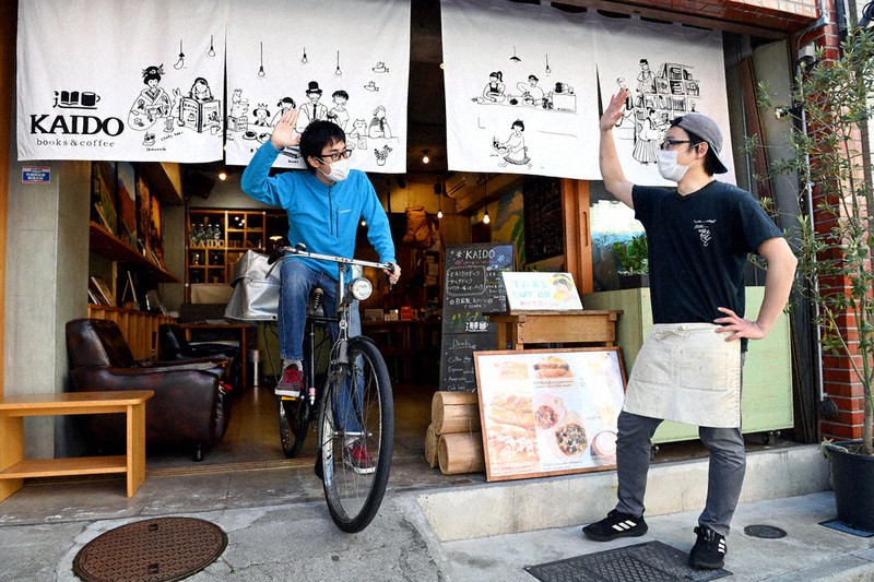 店主の佐藤亮太さん(右)に見送られデリバリーに出発する磯田怜さん=東京都品川区で2020年4月19日、大西岳彦撮影