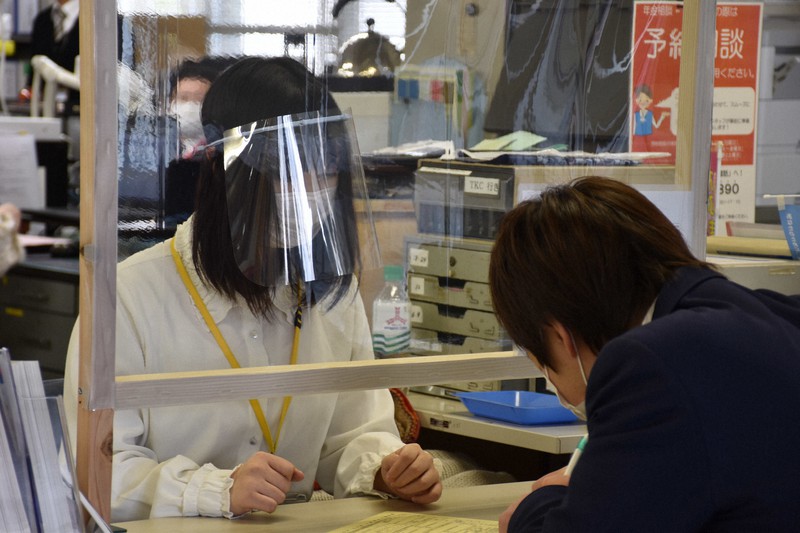 寄贈されたフェースシールドをつけ、窓口業務をする町職員=栃木県壬生町役場で2020年4月27日午後2時11分、増田恵実撮影