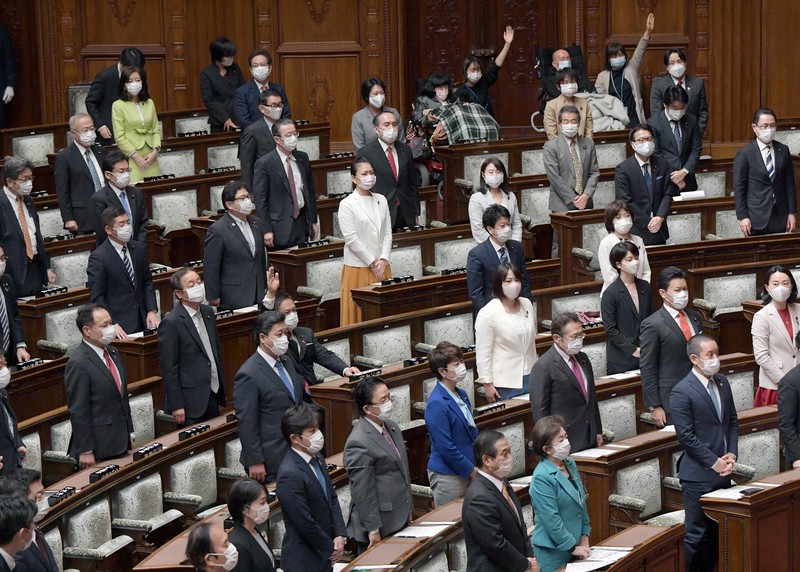 席の間隔が空けられた参院本会議で起立採決する議員たち=国会内で2020年4月10日午前10時7分、竹内幹撮影