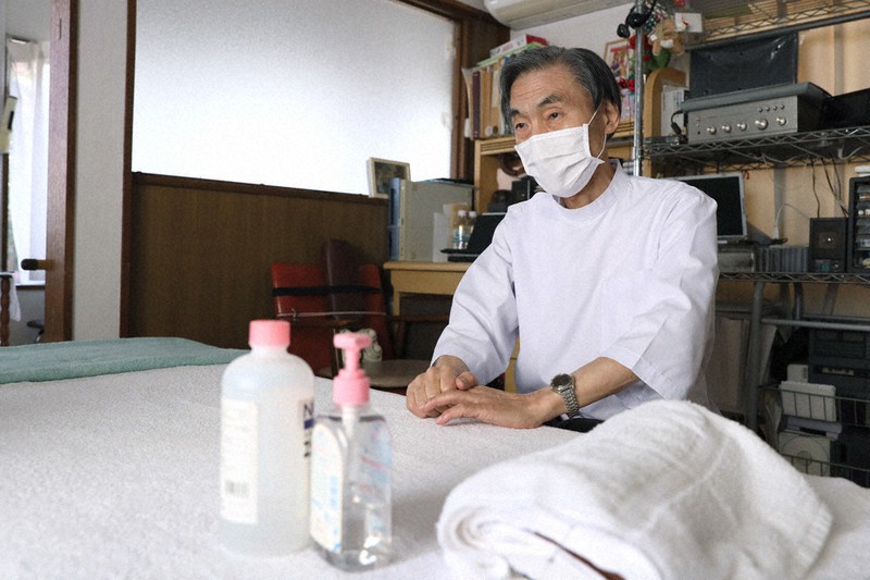 治療院を休業した笹原稔さん。手前はストックがもうないという消毒剤など=東京都品川区で4月、尾籠章裕撮影