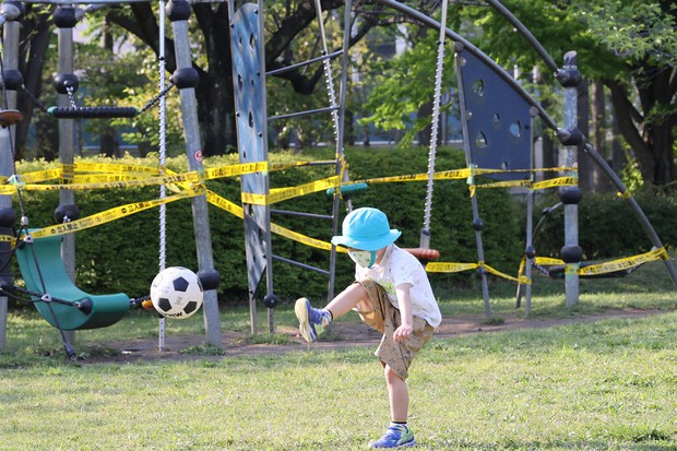 使用禁止となった遊具の近くでボール遊びをする男の子=東京都江東区で2020年4月29日、幾島健太郎撮影