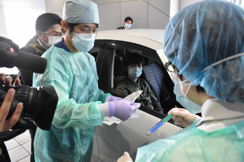 車に乗ったまま検体を採取できるドライブスルー方式のPCR検査の訓練をする医師ら=山梨県中央市で2020年4月28日午後1時57分、金子昇太撮影