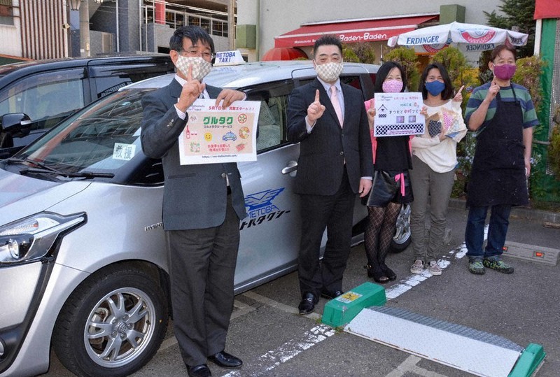 飲食店の料理をタクシーで宅配する「ワン・マツモト」プロジェクトのメンバー=長野県松本市大手4で