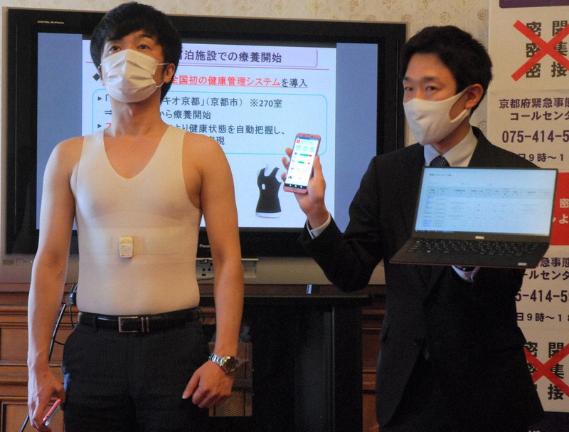 民間宿泊施設の感染者が使うスマートウエア(左)。心拍数、呼吸数、ストレスを自動計測して送信できる=府庁旧本館で2020年5月1日、大川泰弘撮影