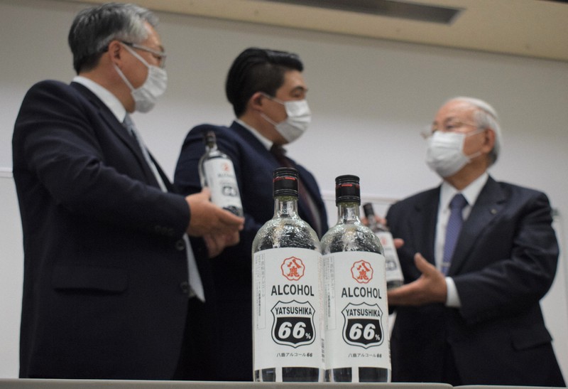 大分県の八鹿酒造が販売する「八鹿アルコール66」。後方は同社の麻生専務(中央)と県医師会の近藤会長=大分市駄原の県医師会で2020年4月30日午後2時16分、津島史人撮影