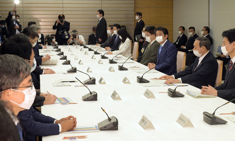 新型コロナウイルス感染症対策本部の会合で緊急事態宣言の延長を表明する安倍晋三首相(右側手前から3人目)=首相官邸で2020年5月4日午後5時5分、竹内幹撮影