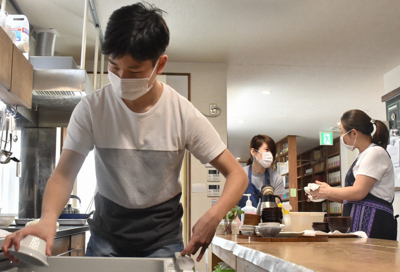 お年寄りや子どもたちが集う地域食堂で手伝いをする高校3年、大平諒さん(左)。「身近に居場所があることは心強い」と話した=盛岡市中ノ橋通1で2020年5月4日12時59分、山田豊撮影