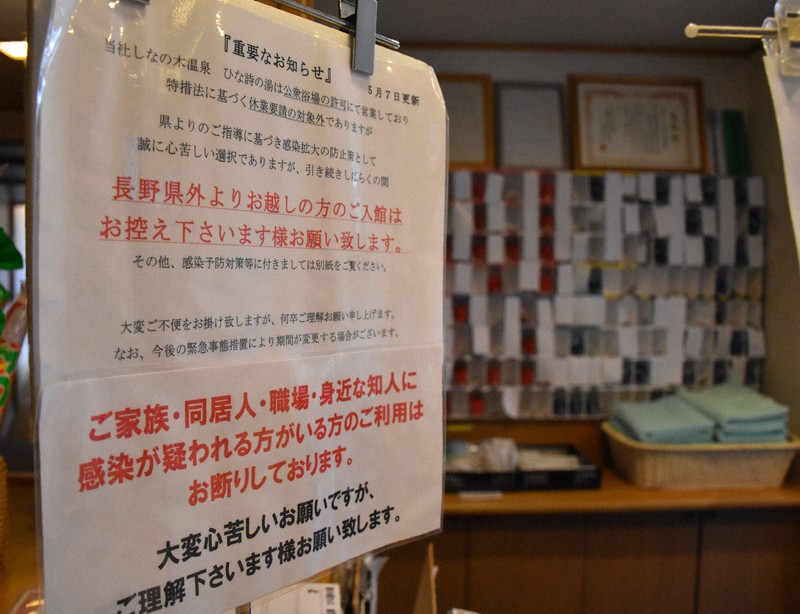 長野県外客に入場を控えるよう呼び掛ける貼り紙。ロッカーの鍵の棚には紙を貼って貸し出しを5分の1に抑える=上田市住吉のしなの木温泉ひな詩の湯で2020年5月8日、原奈摘撮影