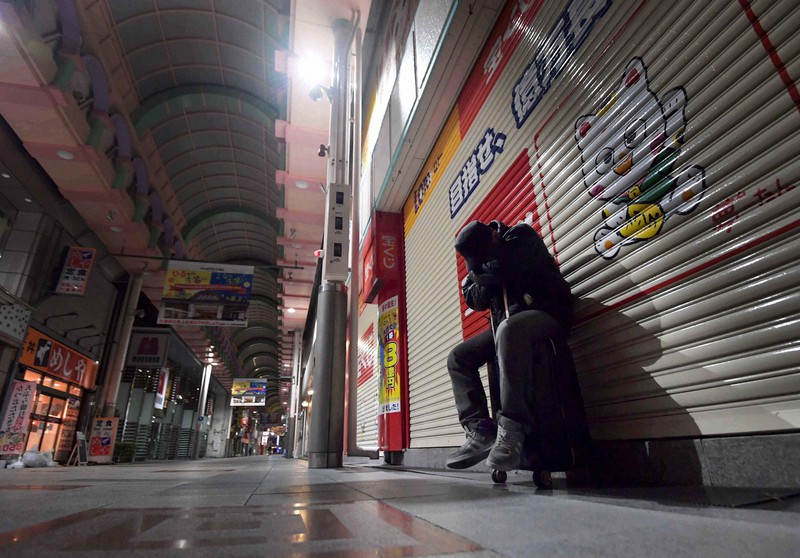 仕事も住む場所も失い、ミナミの商店街で深夜に座り込んでいた男性=大阪市中央区で、平川義之撮影