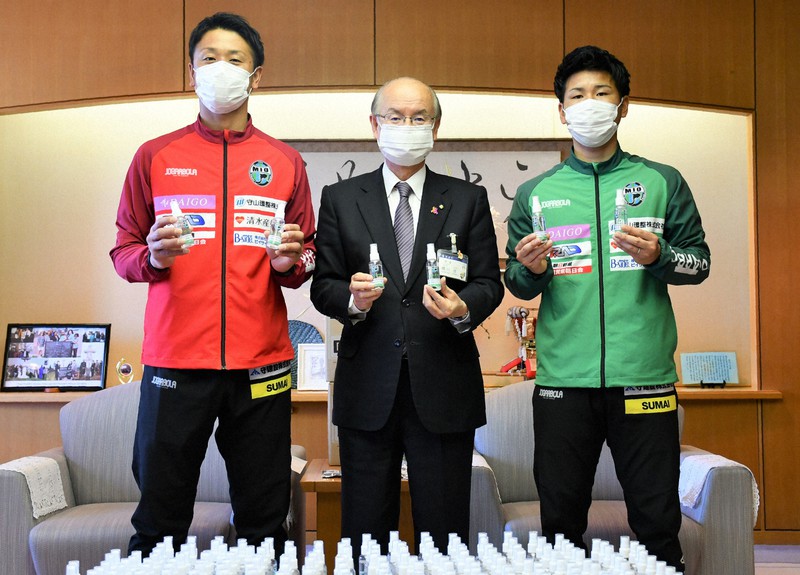橋川渉市長(中央)に消毒スプレーを寄贈したMIOびわこ滋賀の永冨裕尚選手(左)と嘉茂良悟選手=滋賀県草津市役所で2020年4月27日午後2時14分、礒野健一撮影