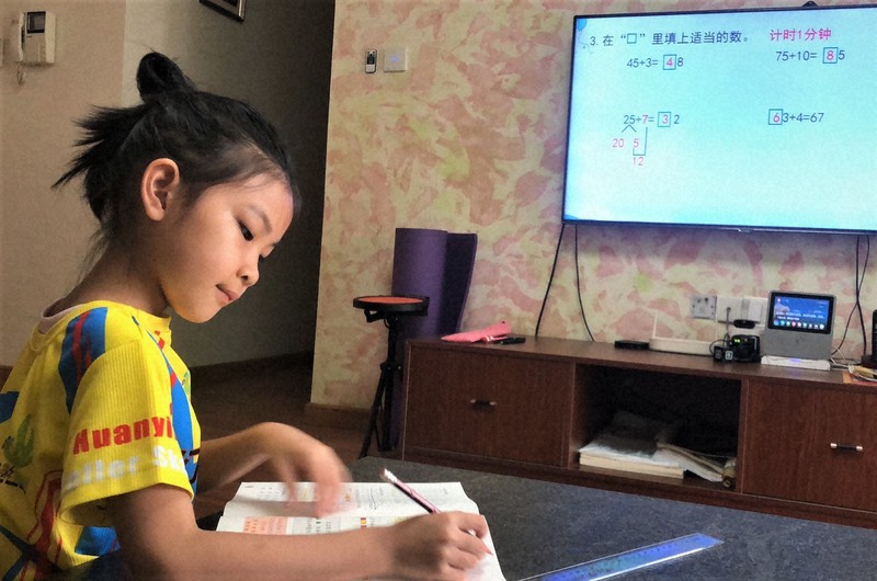 自宅でテレビモニターに向かい、オンライン授業を受ける崔嘉淇さん=中国・南寧市で2020年5月11日、家族提供