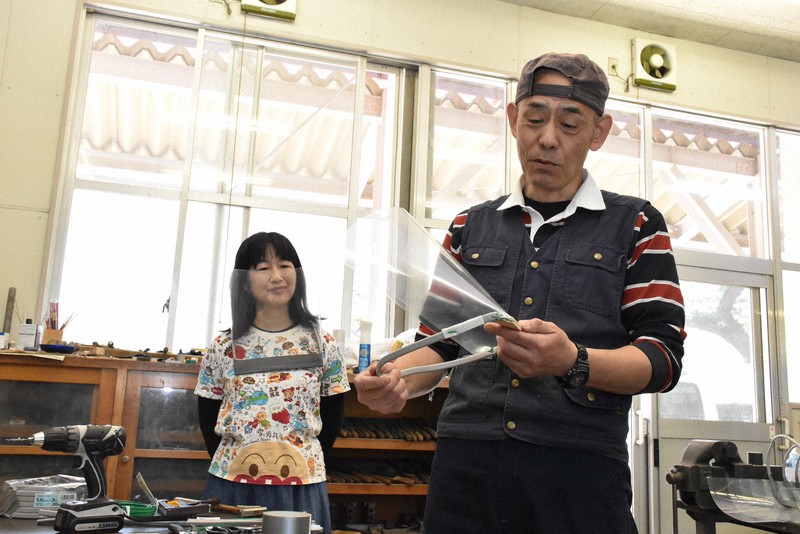 フェースシールドを作る板垣昌悦さん(右)と、実際に着ける伊藤朝子さん=仙台市太白区の宮城県立聴覚支援学校で2020年5月14日午前10時42分、滝沢一誠撮影