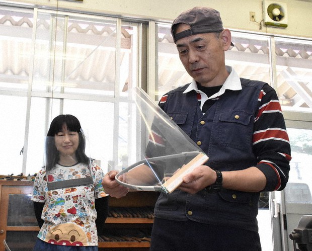 フェースシールドを作る板垣昌悦さん(右)と、実際に着ける伊藤朝子さん=仙台市太白区の県立聴覚支援学校で