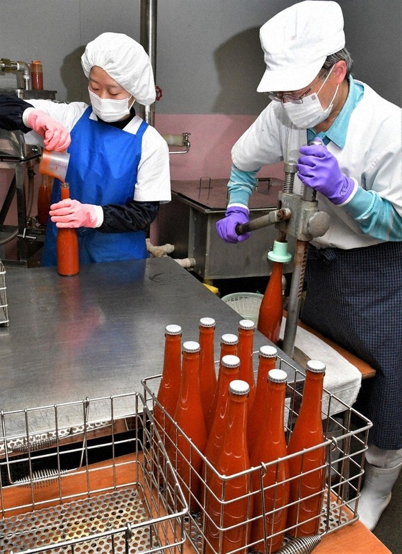 手作業で進められるジュース製造。新たな委託先のトマトを加工した=埼玉県小鹿野町の大平戸農園で