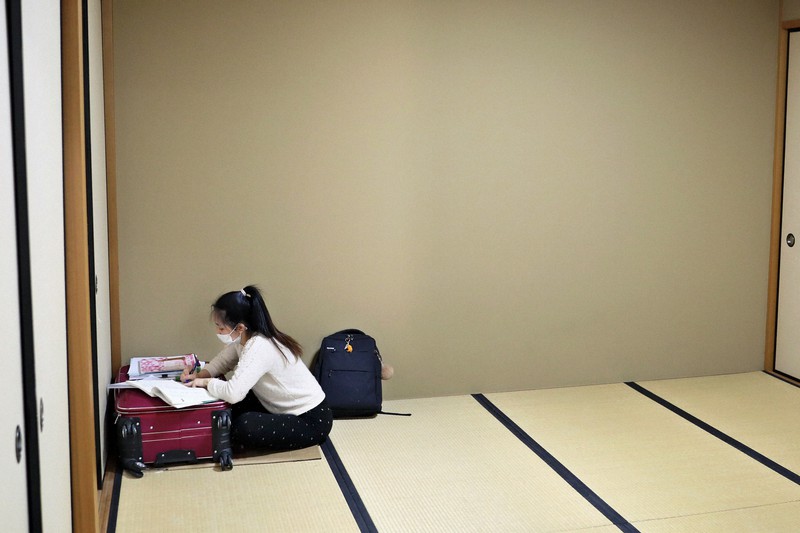 身を寄せた寺院の部屋でスーツケースの上に教材を広げ、日本語を勉強するベトナム人のドー・ティー・トゥー・フォンさん=東京都港区で2020年4月30日、小川昌宏撮影