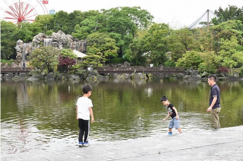 公園の池で遊ぶ親子=高知市桟橋通6のわんぱーくこうちで、北村栞撮影