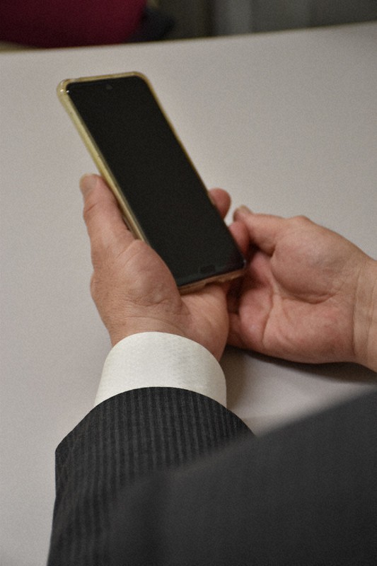 面会ができなくなった母親との連絡に使ったスマートフォンを手にする男性=東京都千代田区で2020年5月12日、関谷俊介撮影