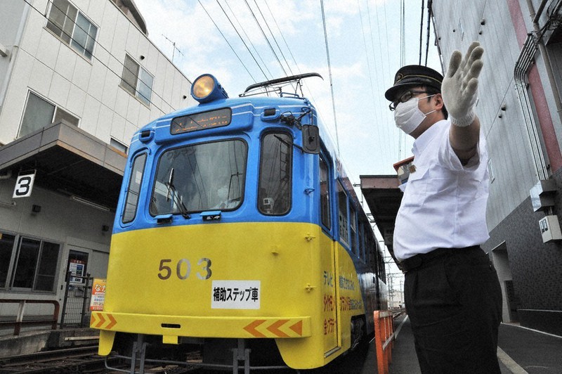 阪堺電車我孫子道駅の踏切で、周囲の安全を確認する田中明城さん。この踏切には遮断機がないため、通りがかった社員が適宜、横断者らに注意を促すという=大阪市住吉区の同駅で、高橋昌紀撮影