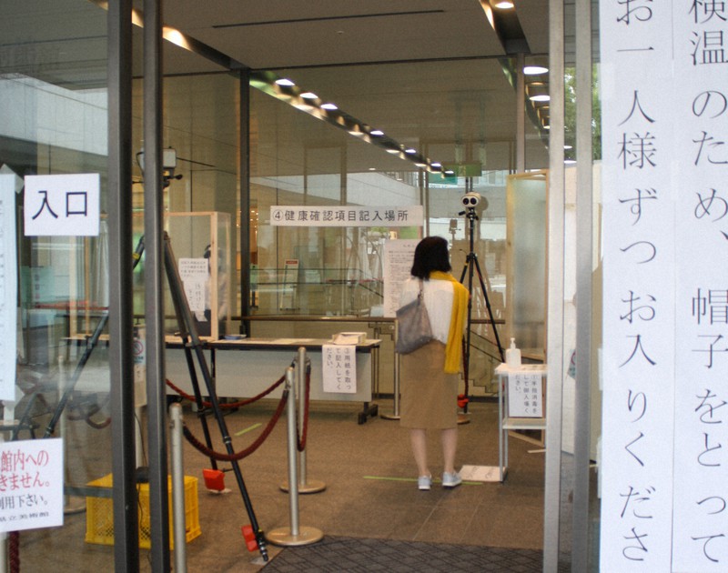 再開した広島県立美術館の来場者入り口には注意書きが貼られているほか、奥には消毒液も設置され、ものものしい雰囲気。自動で検温できるサーモグラフィーも見える=広島市中区の同美術館で2020年5月15日午後2時26分、宇城昇撮影