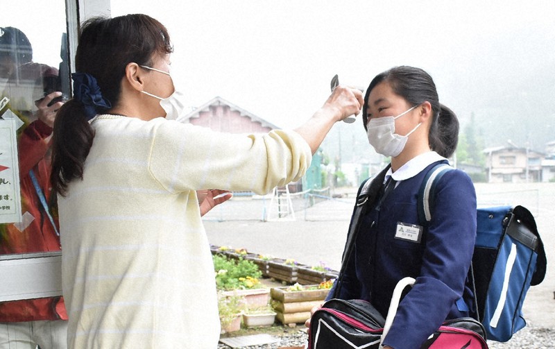 校舎入り口で検温を受ける生徒(右)=群馬県南牧村の南牧中学校で2020年5月18日、鈴木敦子撮影