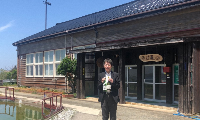 特区新設で清酒が造れるようになった新潟県佐渡市の「学校蔵」と、尾畑酒造の平島健社長=尾畑酒造提供