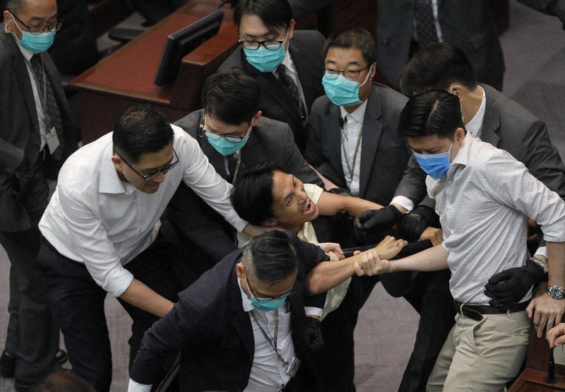 立法会で親中派と民主派の対立が激化し、警備員に取り押さえられる民主派議員(中央)=香港で2020年5月18日、AP
